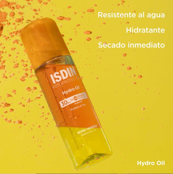 protección solar 30 SPF Isdin Hidro Oil semisumergido en un aceite de tonos anaranjados con burbujas